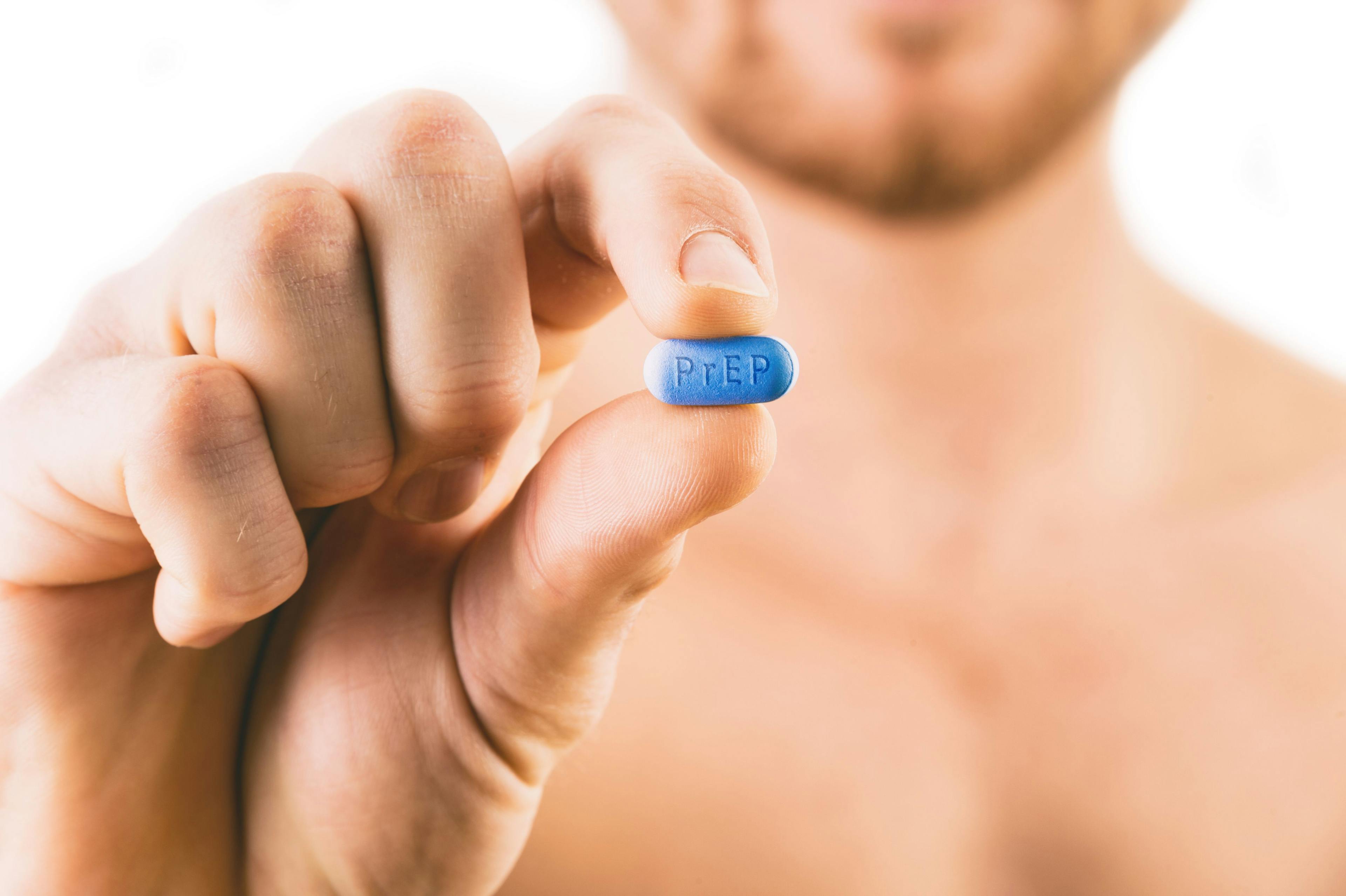 Man holding a pill used for Pre-Exposure Prophylaxis (PrEP)
