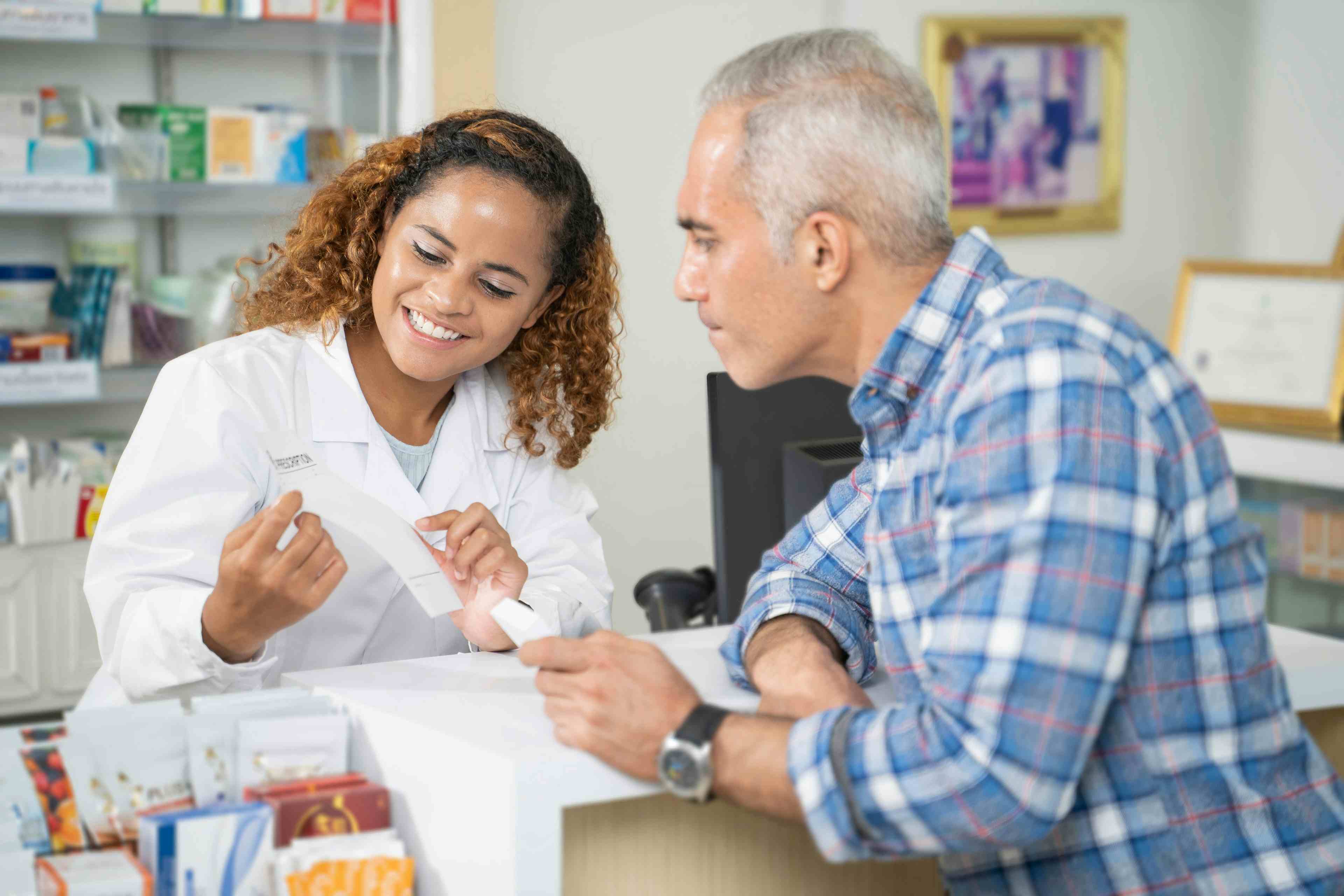 Female pharmacist assists a patient with their prescriptions.