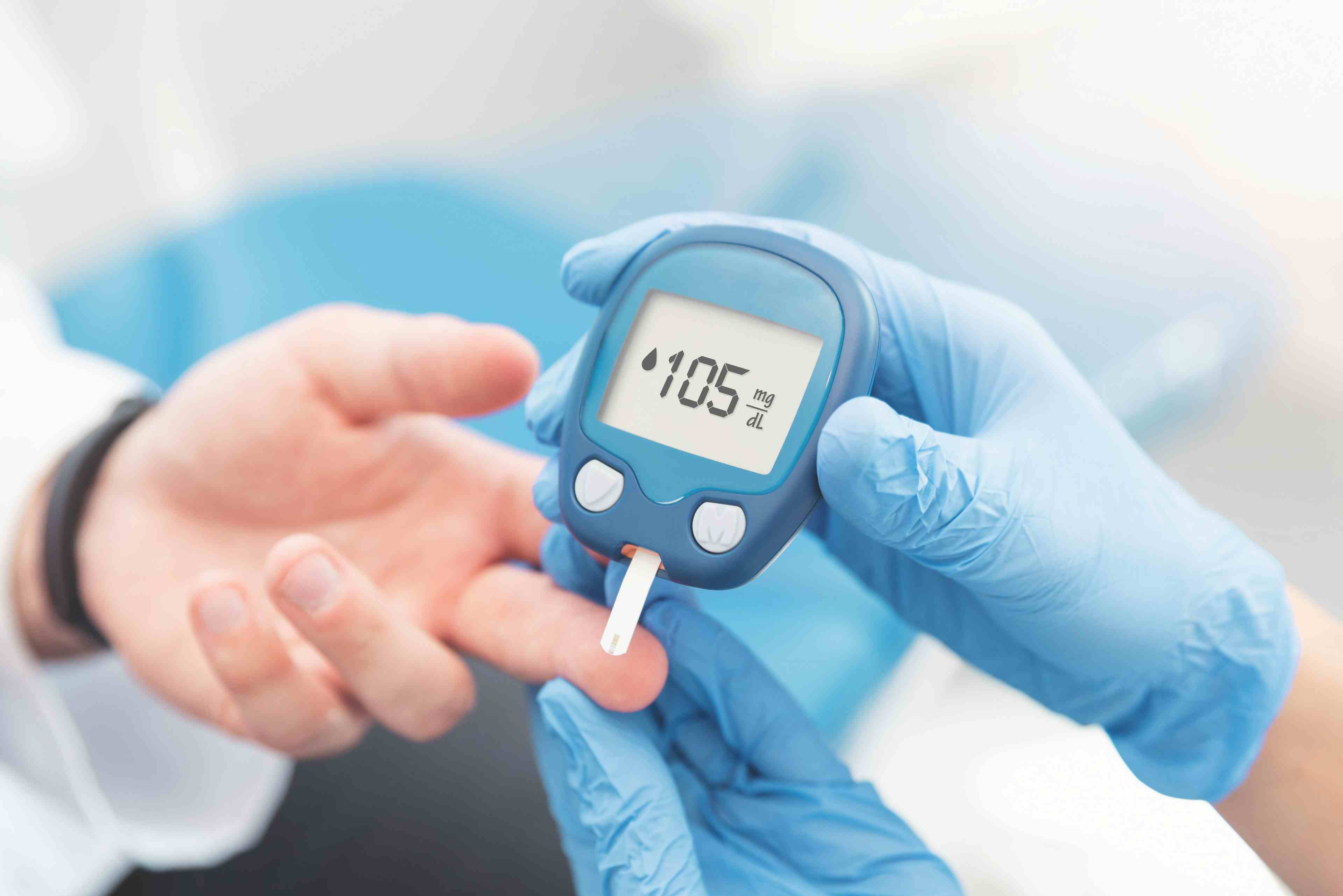 Doctor checking blood sugar level with glucometer