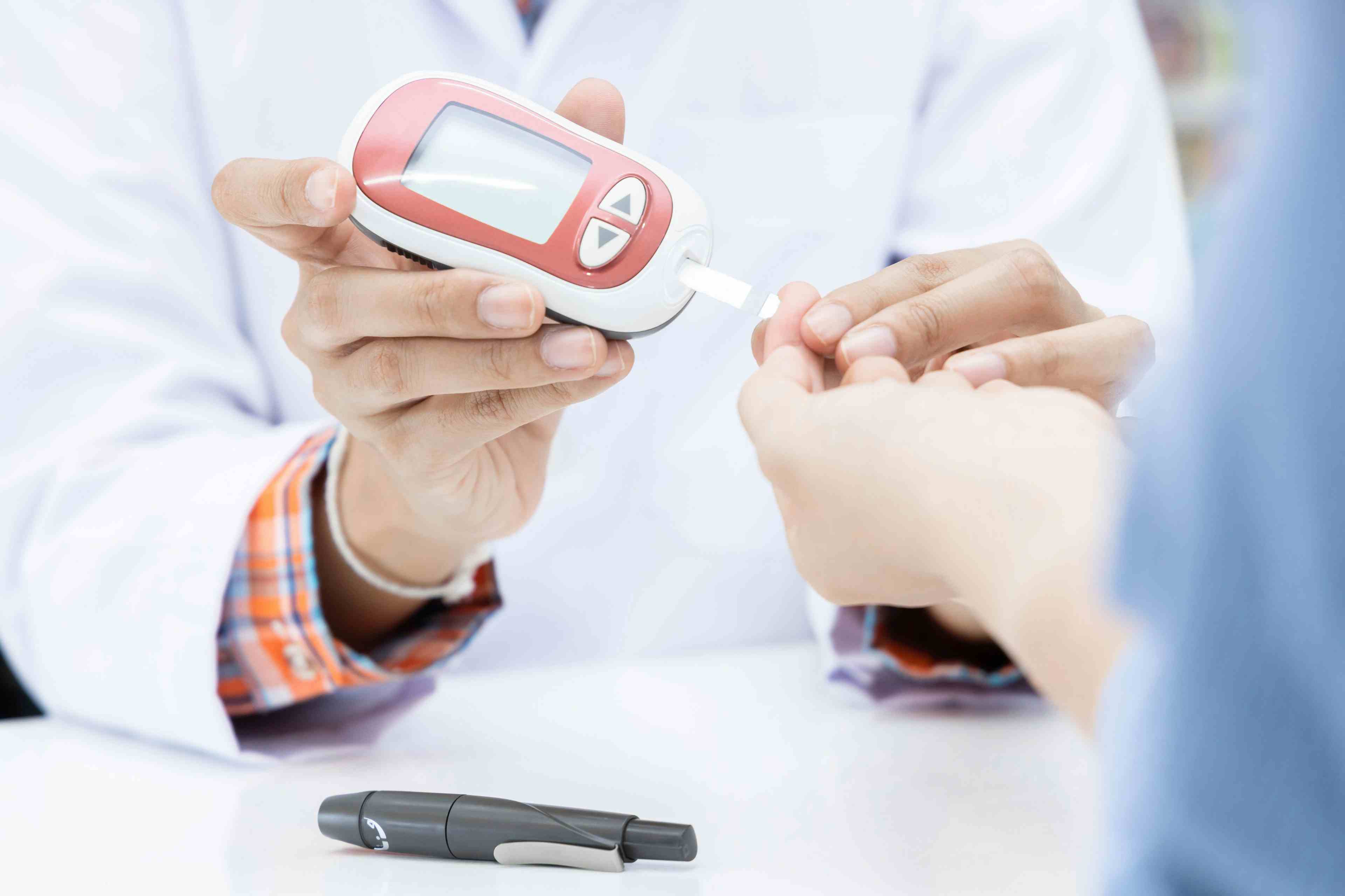 Pharmacist helping patient use glucose monitor -- Image credit: Kalyakan | stock.adobe.com