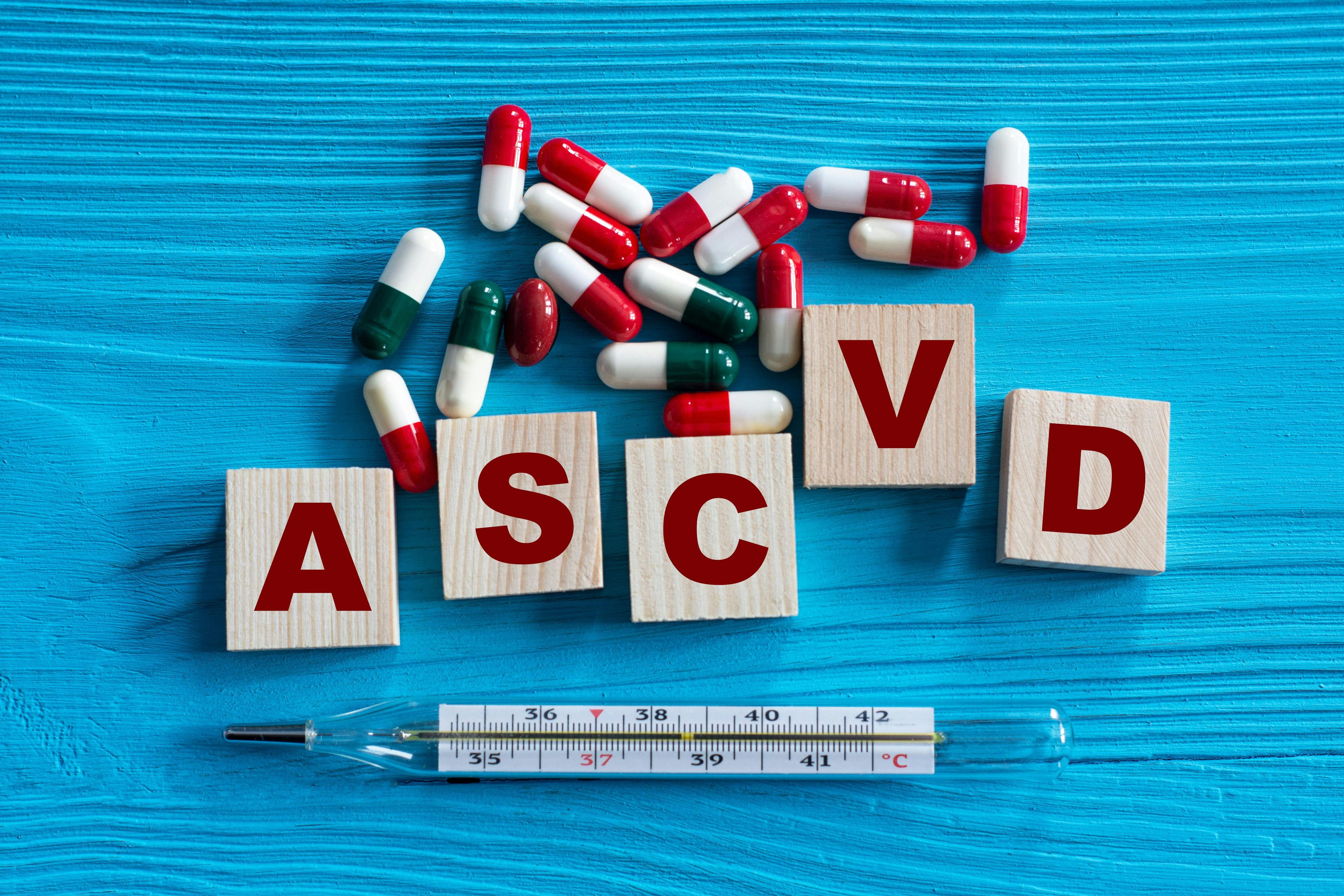 ASCVD - acronym on wooden cubes on a blue background with tablets and thermometer