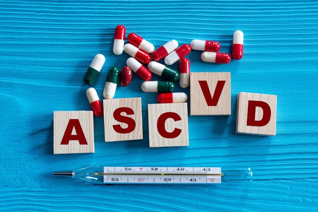 ASCVD - acronym on wooden cubes on a blue background with tablets and thermometer