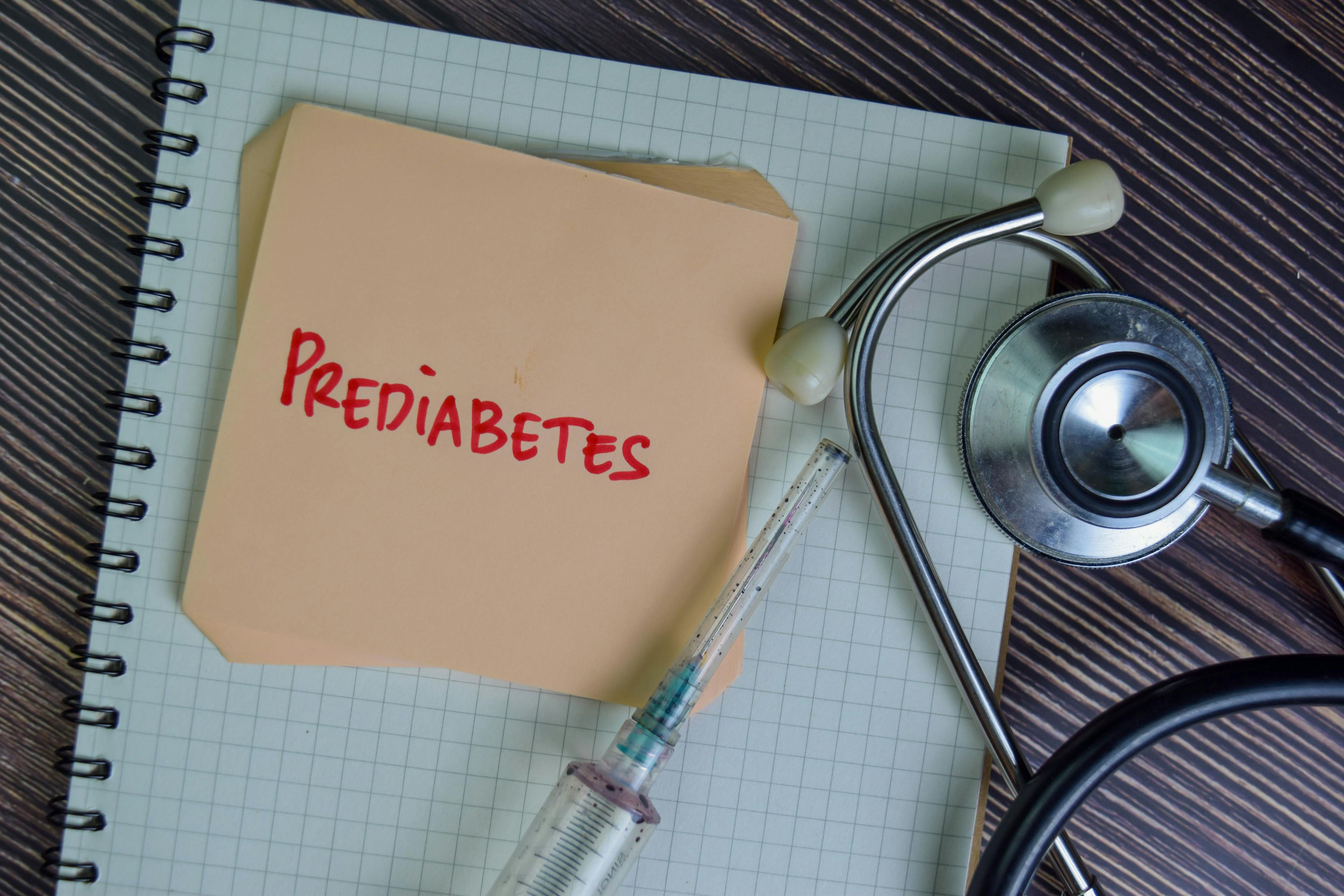 Prediabetes write on sticky notes isolated on Wooden Table.