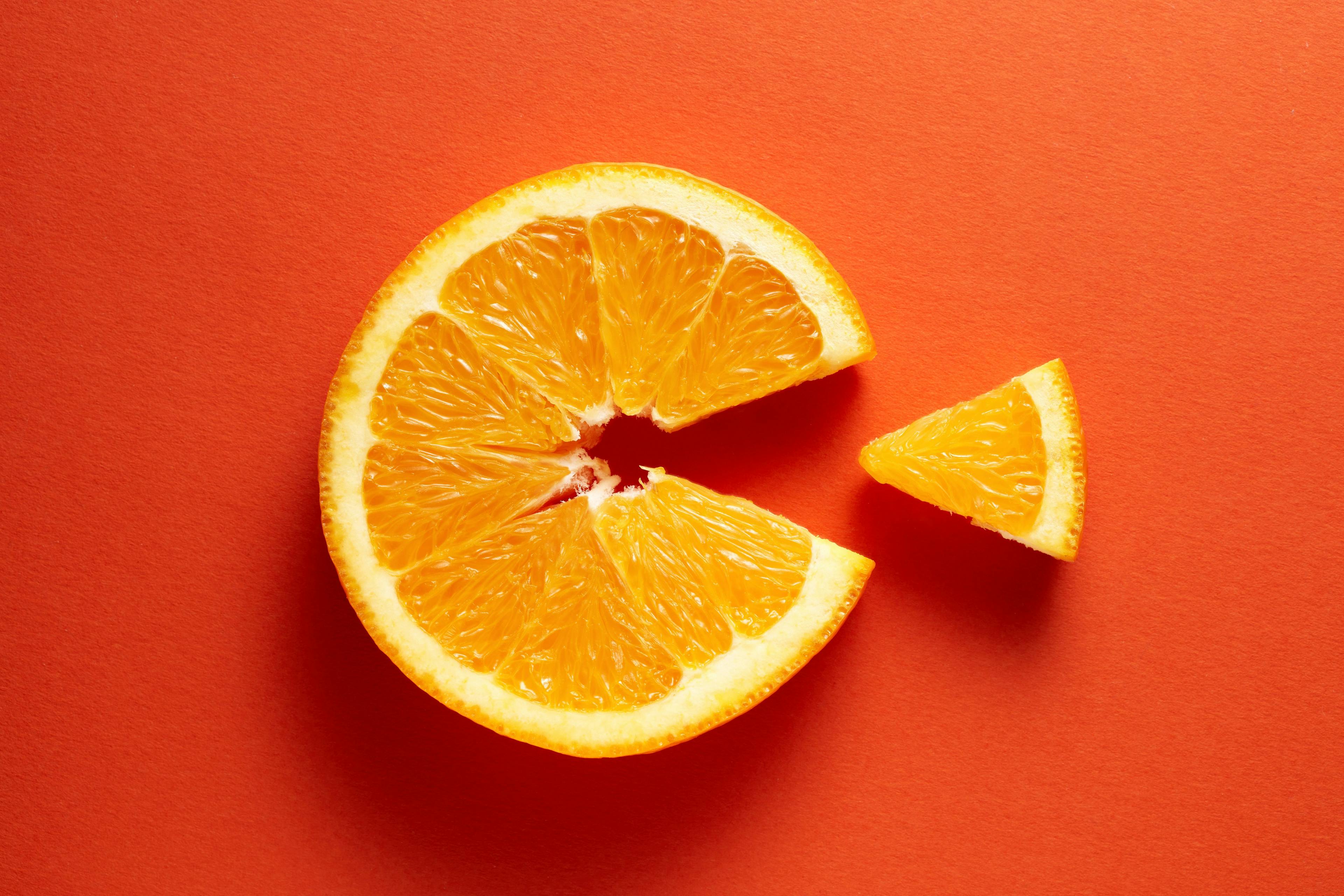 Orange slice symbolizing vitamin c is eating the cut out piece on orange background - Image credit: Cagkan | stock.adobe.com 