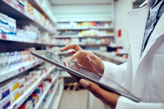 Closeup of hands of young female pharmacist checking inventory in medical store using digital tablet - Image credit: StratfordProductions | stock.adobe.com