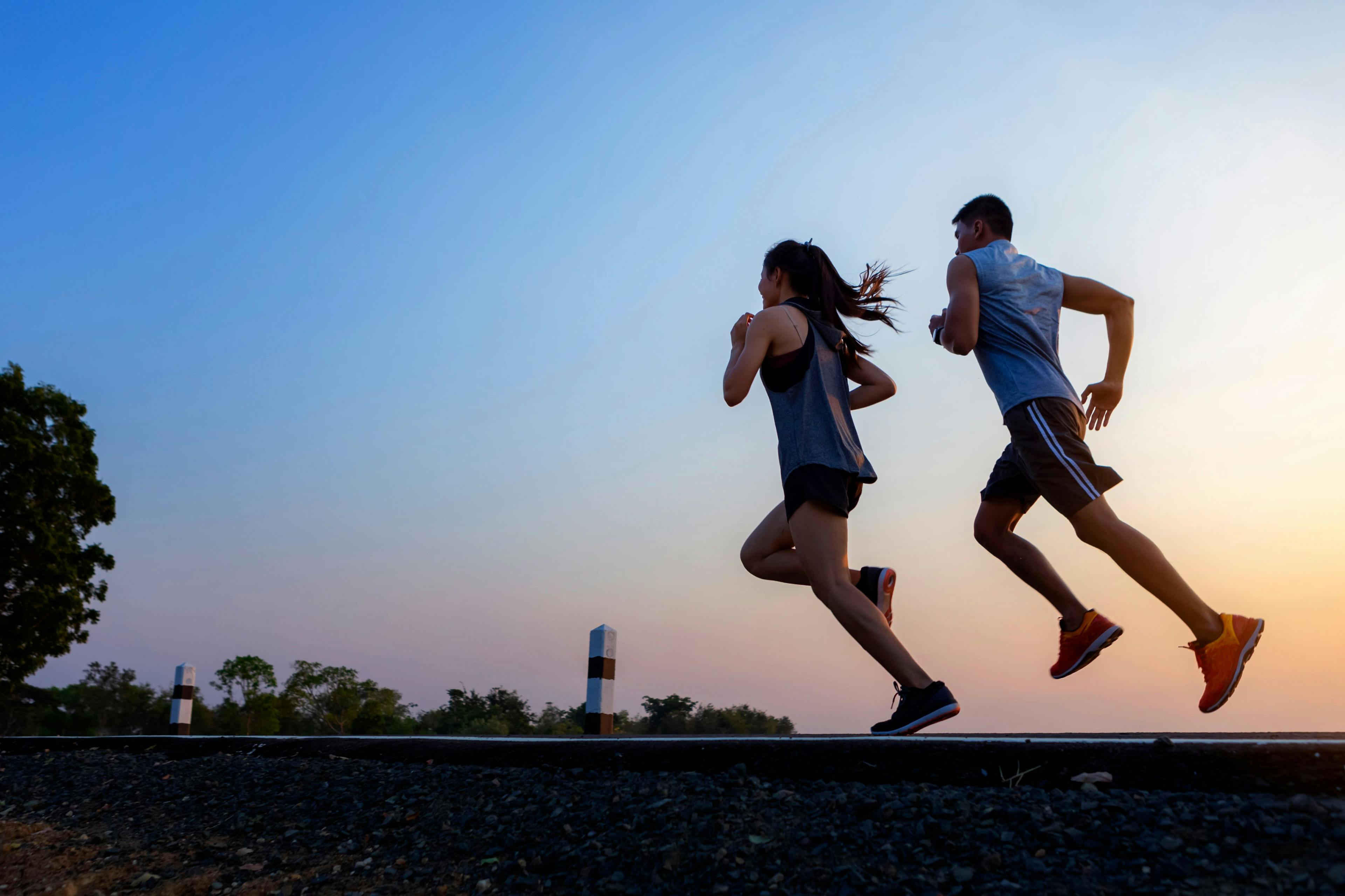 Running at sunrise couple exercising for marathon and workout | Image Credit: bunyarit - stock.adobe.com