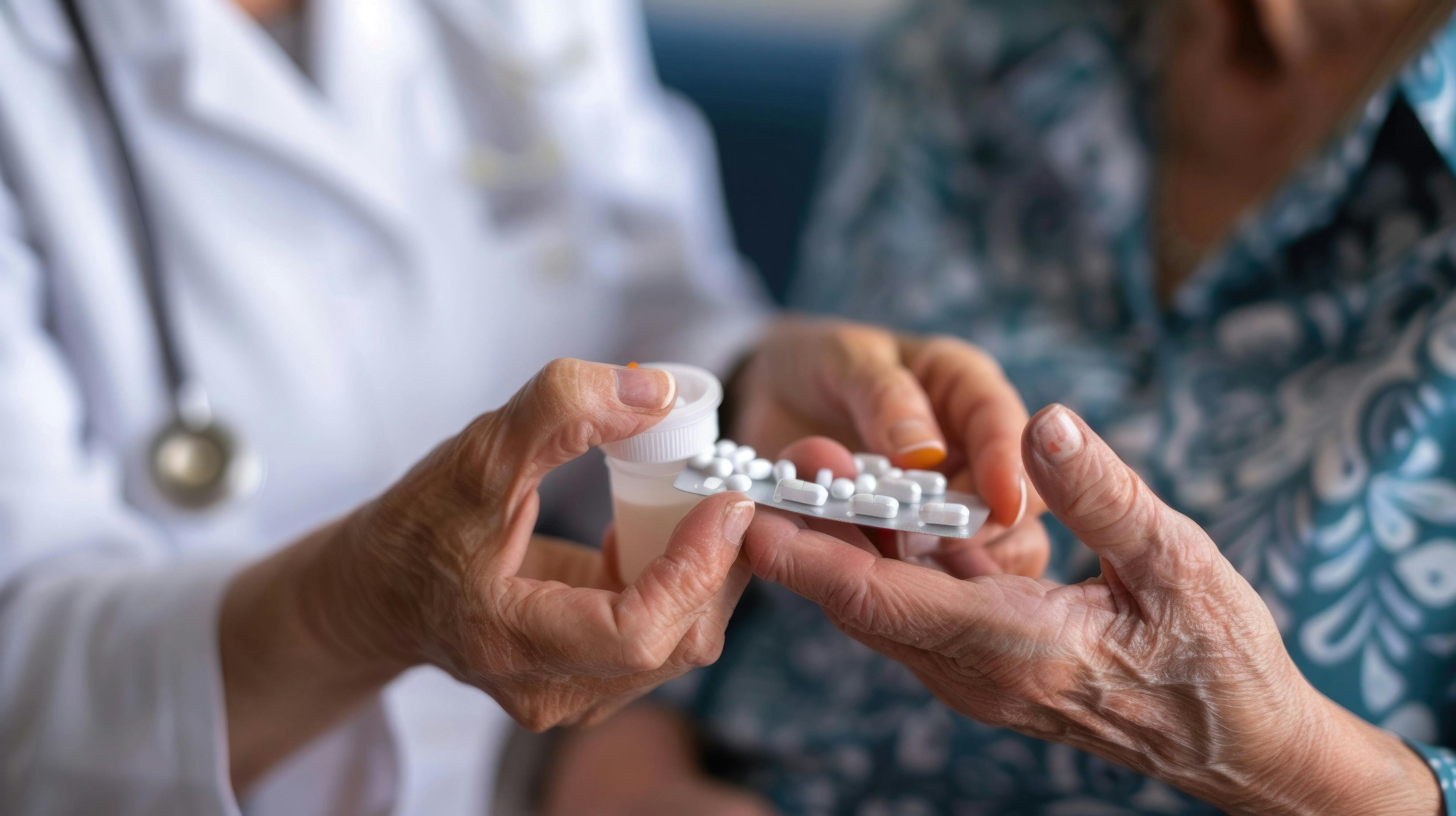 A doctor hands over a strip of pills to an elderly patient, ensuring proper medication management - Image credit: sommersby | stock.adobe.com