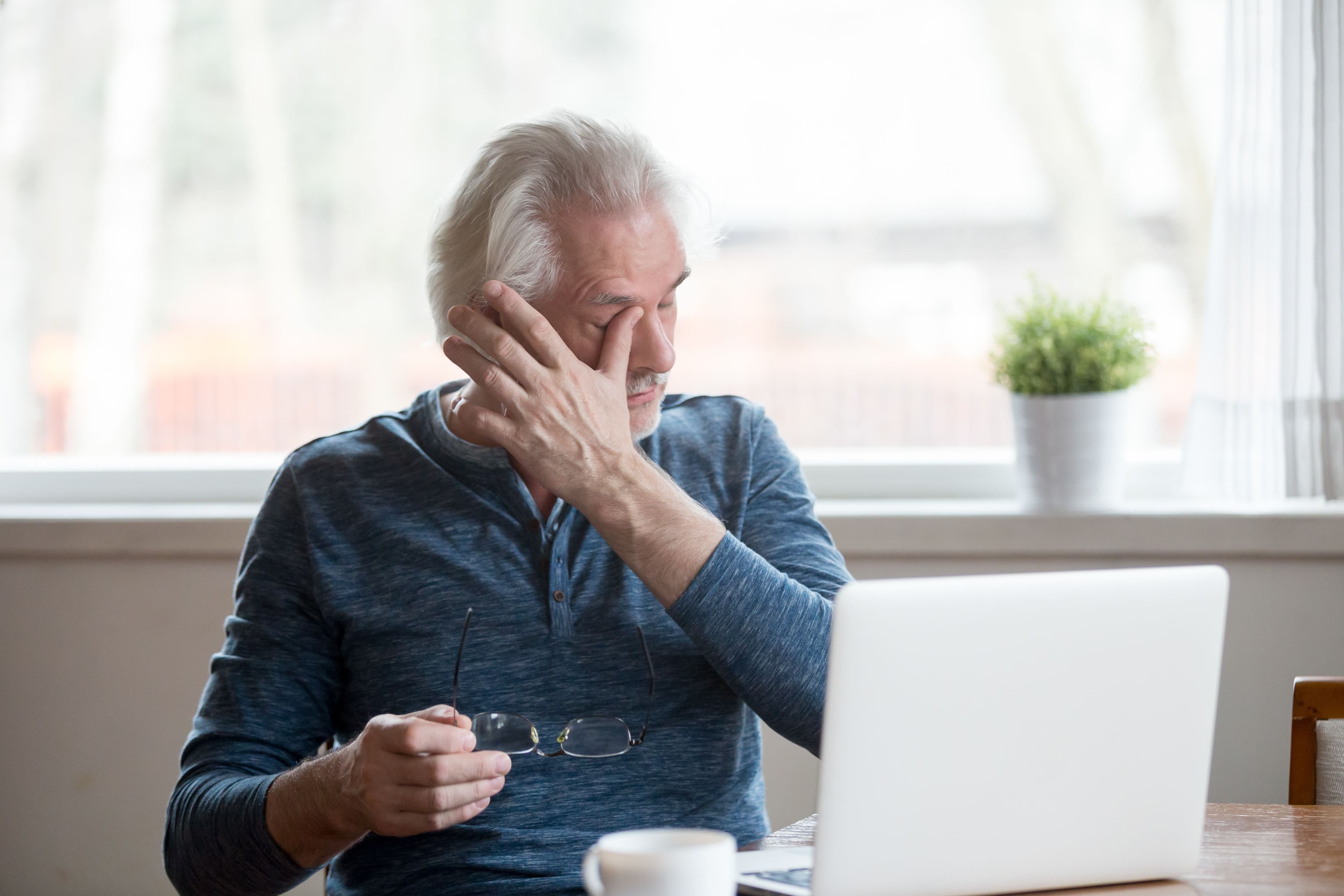 Fatigued mature old man taking off glasses suffering from tired dry irritated eyes after long computer use, senior middle aged male feels eye strain problem or blurry vision working on laptop at home - Image credit: fizkes | stock.adobe.com 