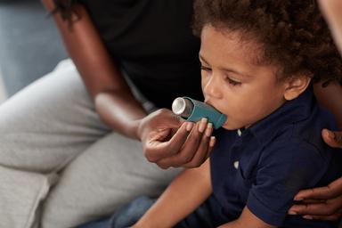 Mother helping her child with an asthma inhaler -- Image credit: DragonImages | stock.adobe.com