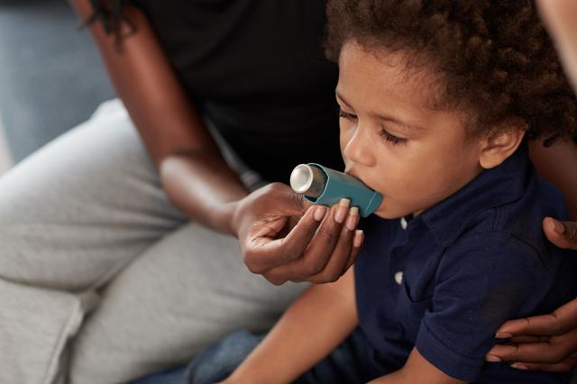 Mother helping her child with an asthma inhaler -- Image credit: DragonImages | stock.adobe.com