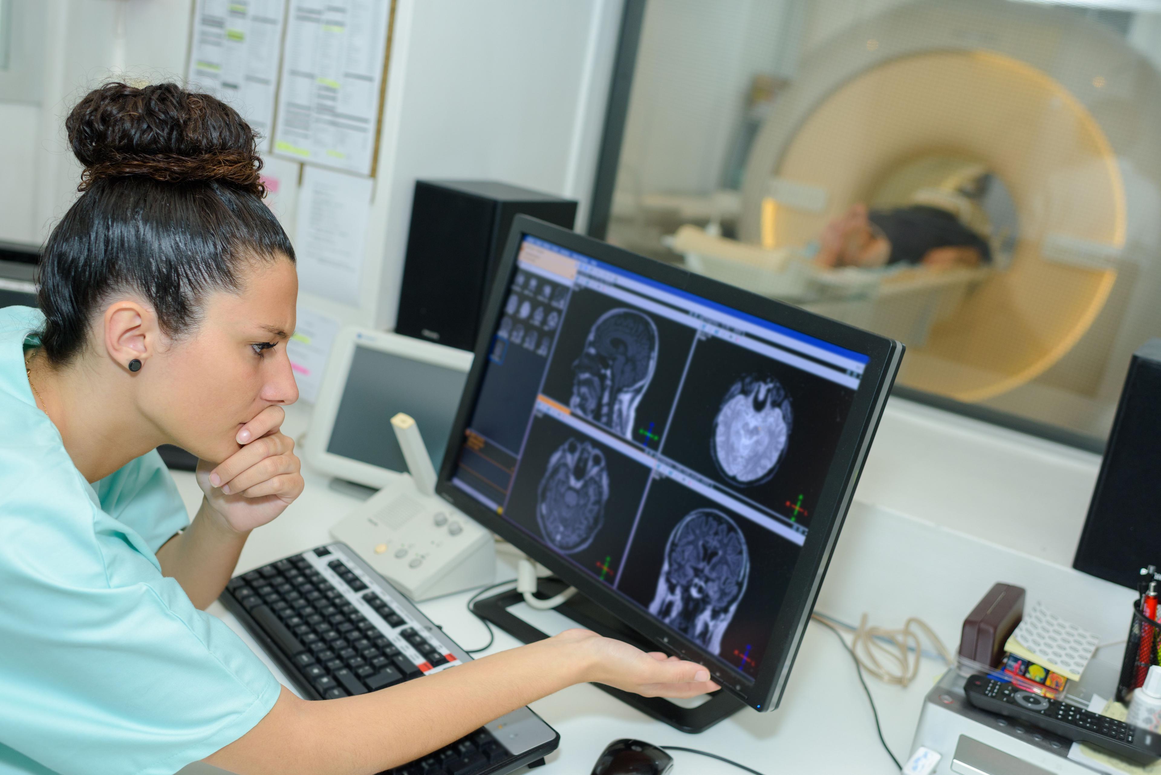 Health care worker looking at MRI scans -- Image credit: auremar | stock.adobe.com