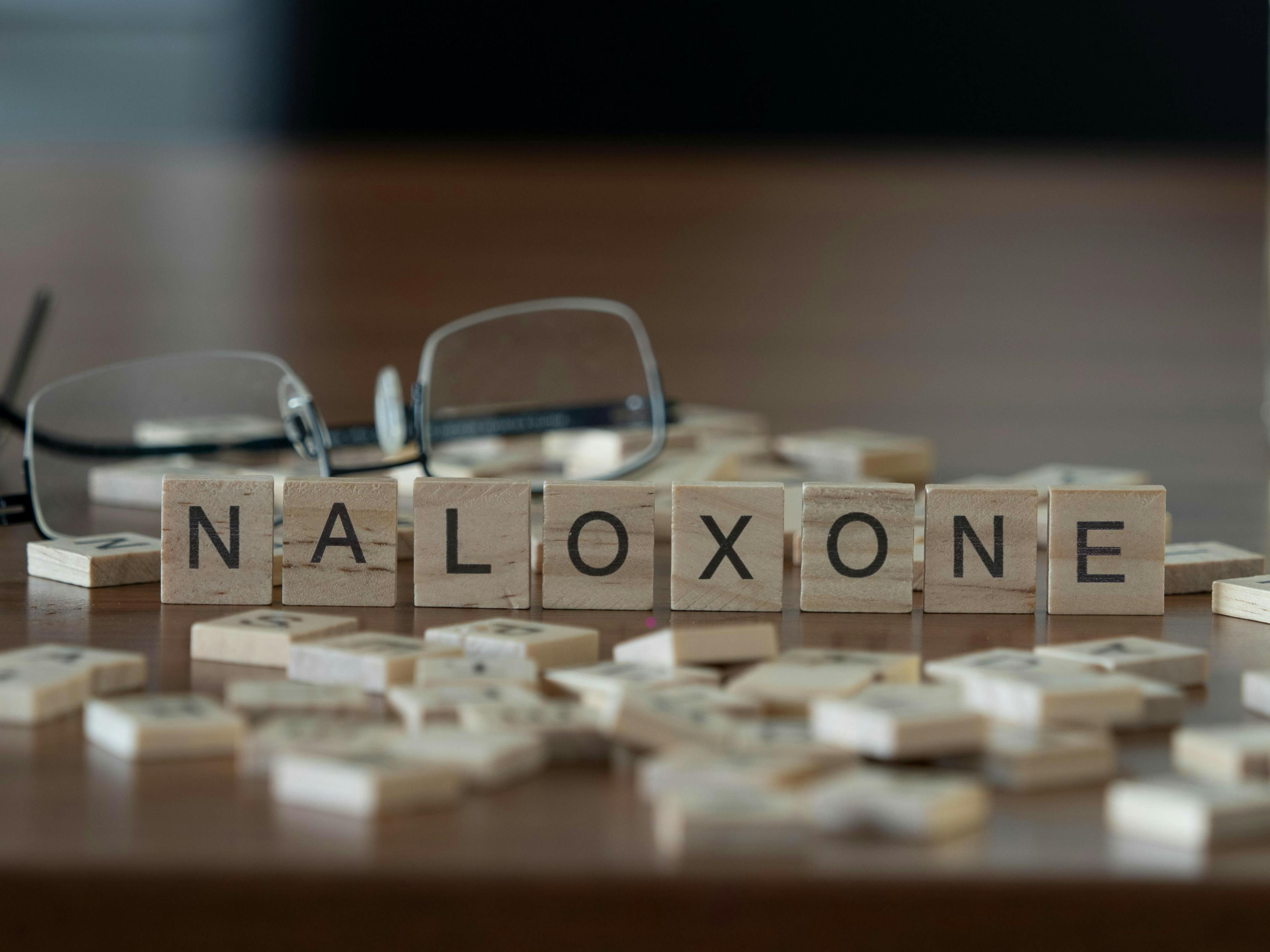 Naloxone concept represented by wooden letter tiles.
