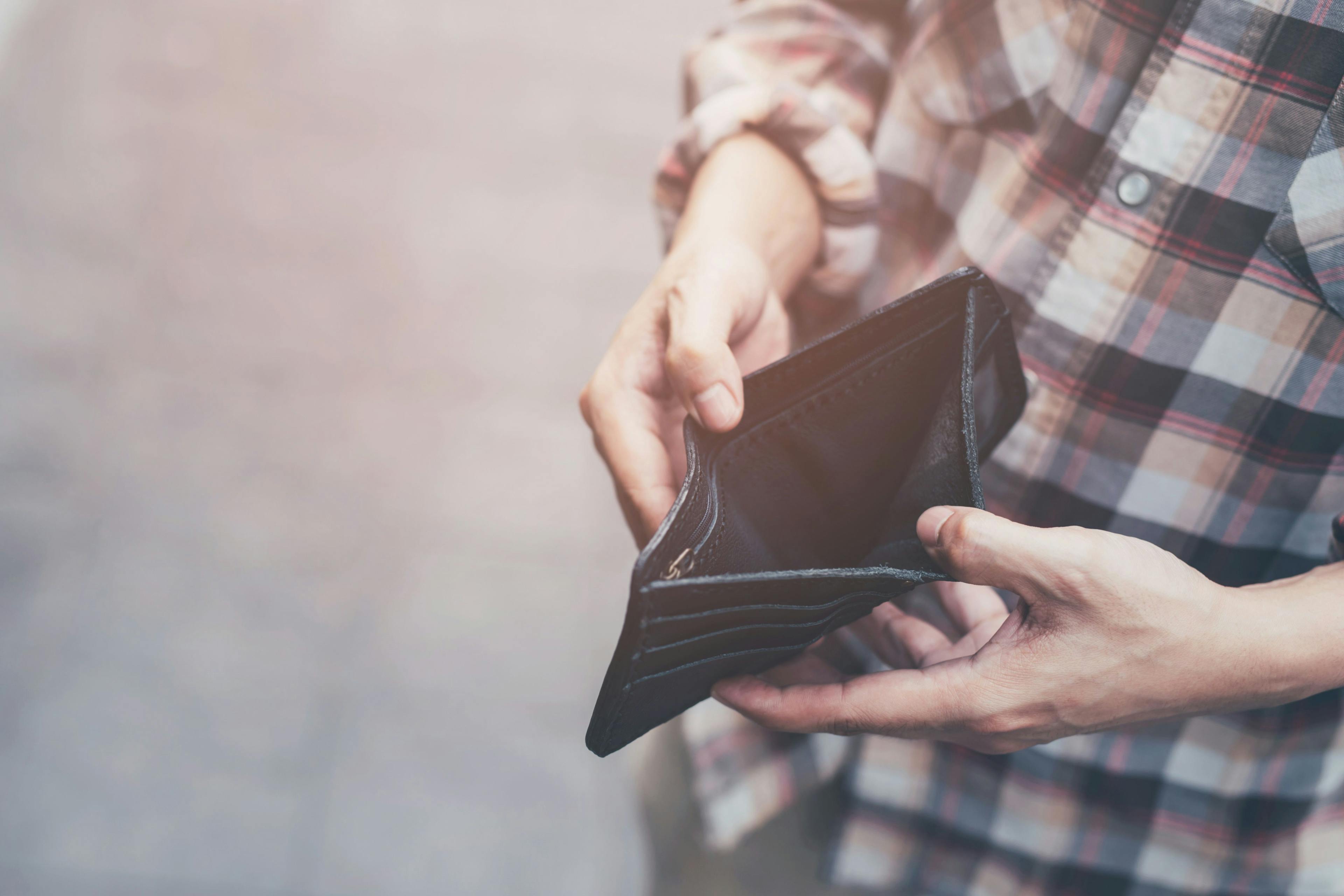 Person holding empty wallet -- Image credit: methaphum | stock.adobe.com 