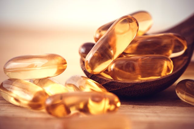 Close up the vitamin D and Omega 3 fish oil capsules supplement on wooden plate for good brain , heart and health eating benefit - Image credit: Cozine | stock.adobe.com