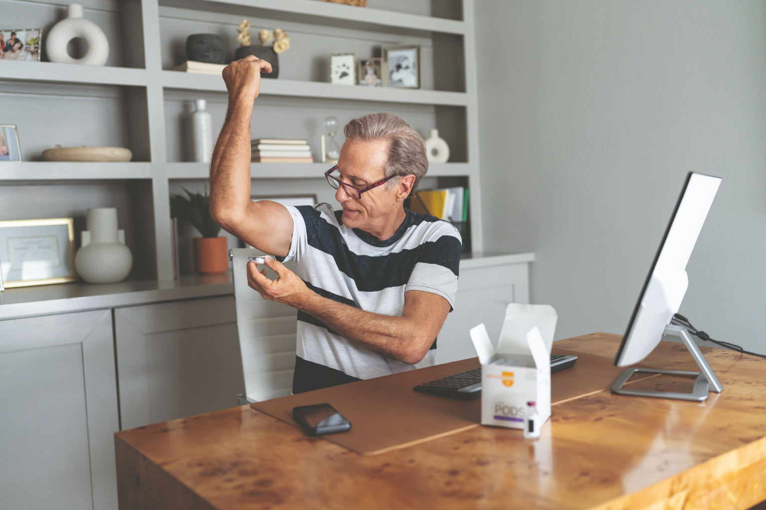 Older man applying a continuous glucose monitor on his arm for diabetes