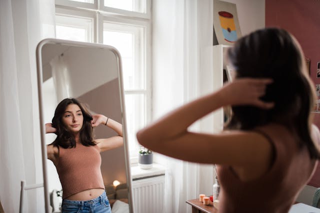 Teenage girl looking at herself in the mirror -- Image credit: Halfpoint | stock.adobe.com