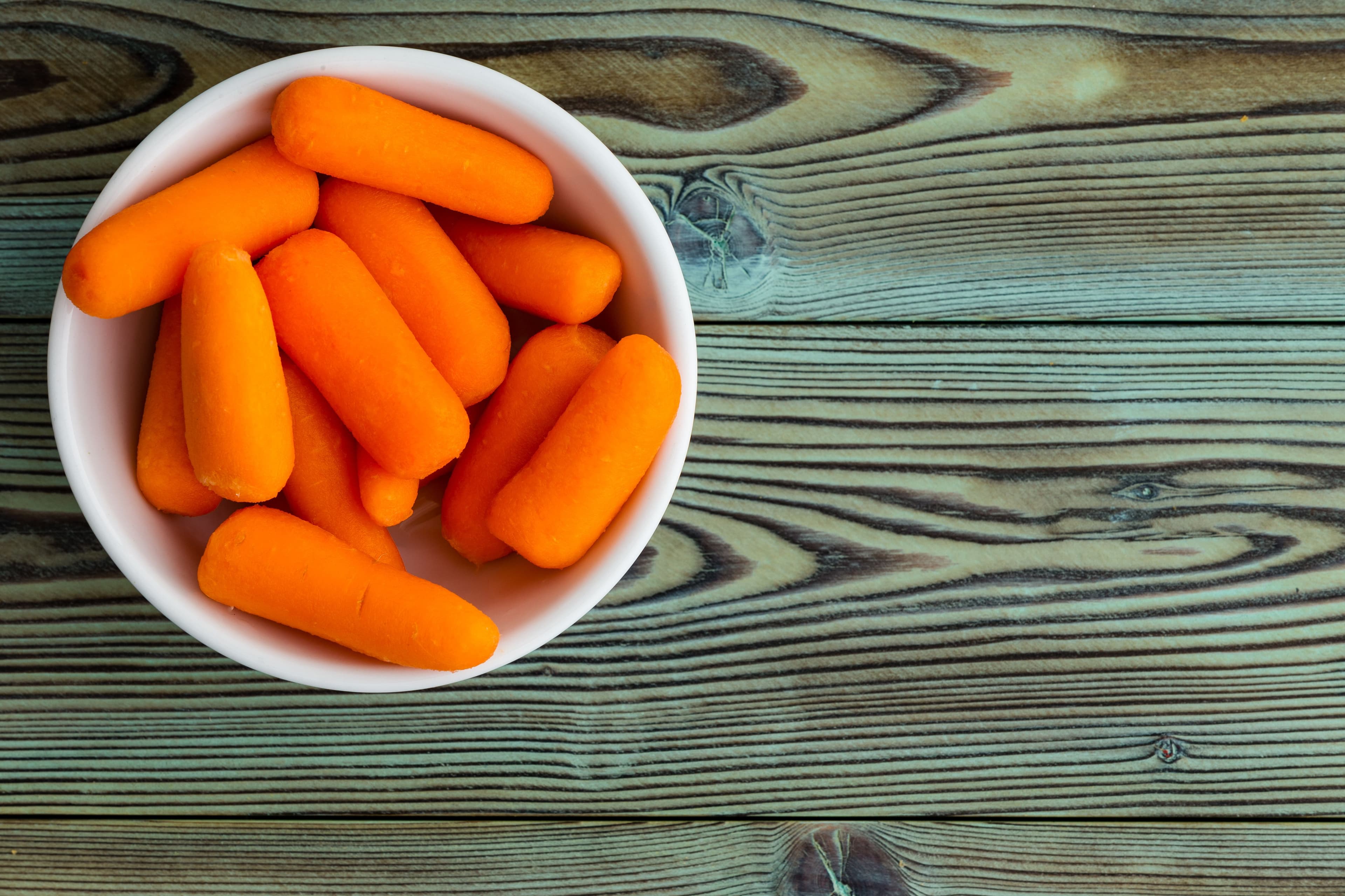 Small ceramic bowl of fresh baby carrots - Image credit: Ozgur Coskun | stock.adobe.com