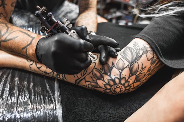 Close up of a person receiving a tattoo on their arm.