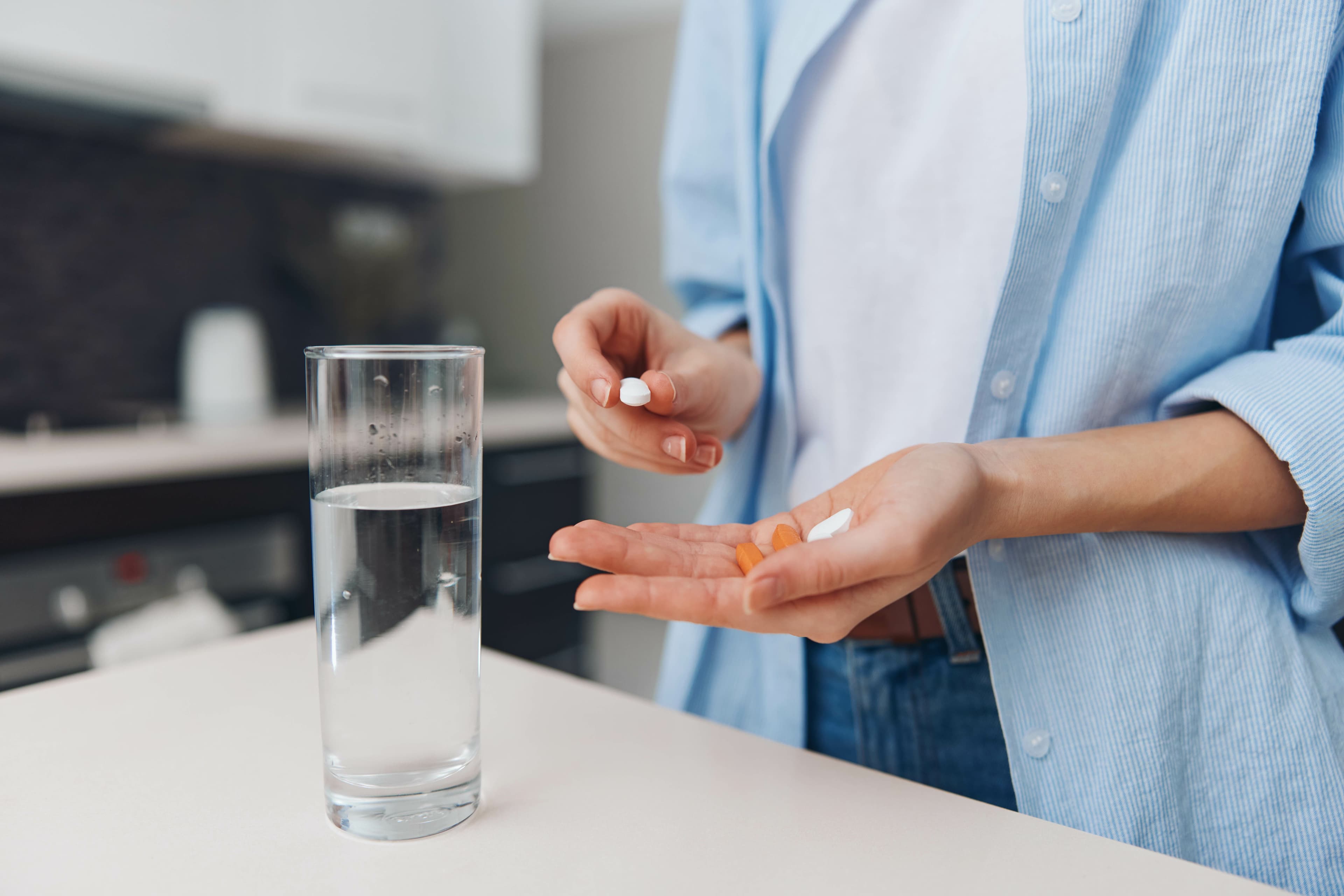 Woman taking pills with a glass of water