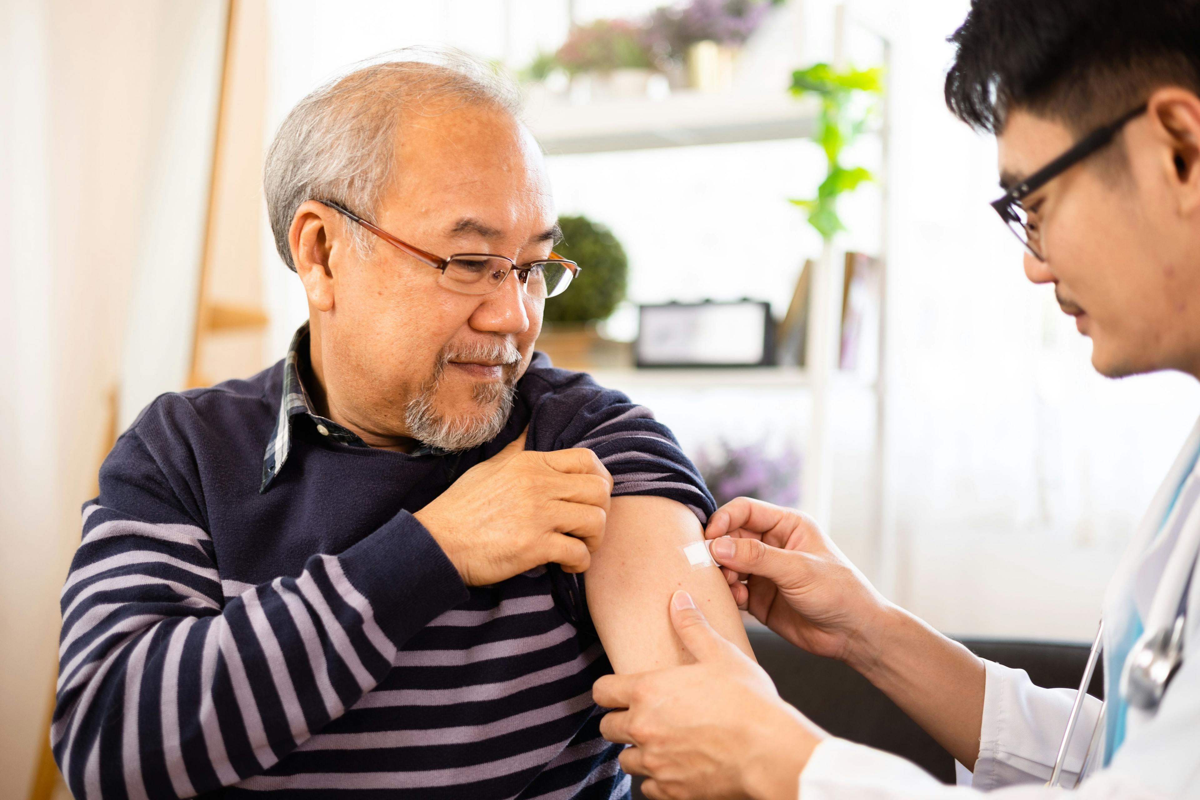 Older man receiving a flu shot at the pharmacy, influenza, pharmacist