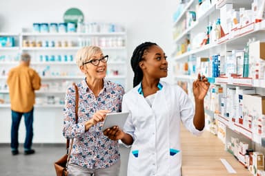 Pharmacist assists senior woman in buying medicine in pharmacy - Image credit: Drazen | stock.adobe.com 