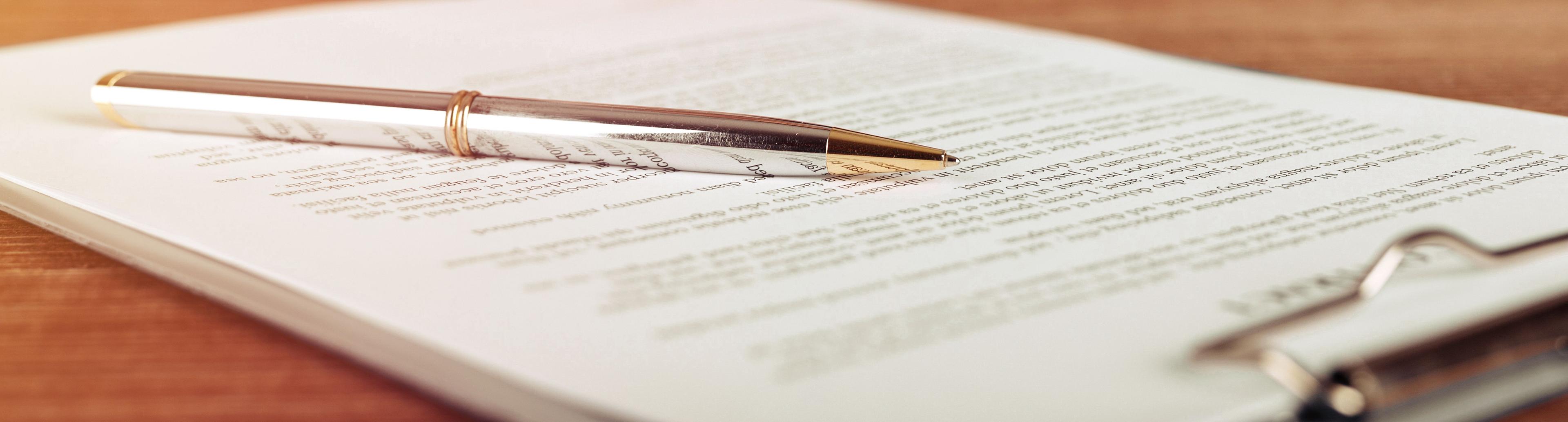 Pen lying on a contract or application form, wide angle view - Image credit: MP Studio | stock.adobe.com