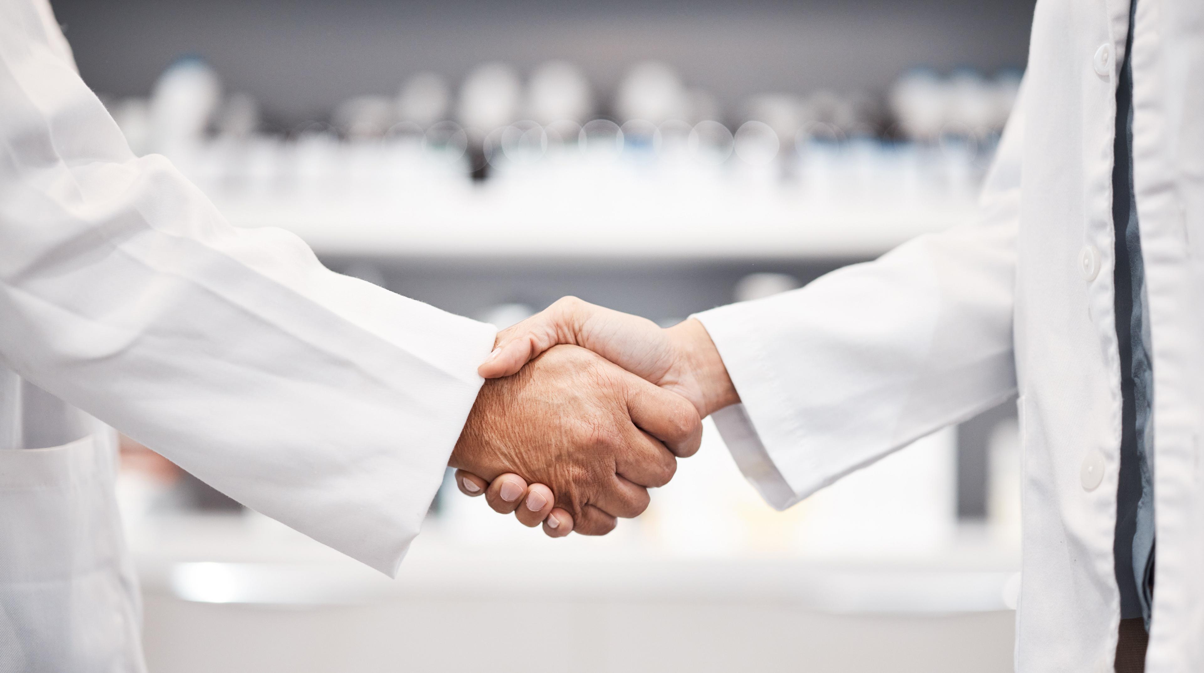 Doctor, handshake and partnership in healthcare, medicine or trust for collaboration, unity or support at lab. Team of medical experts shaking hands in teamwork for agreement or success at pharmacy - Image credit: Malik E/peopleimages.com | stock.adobe.com 