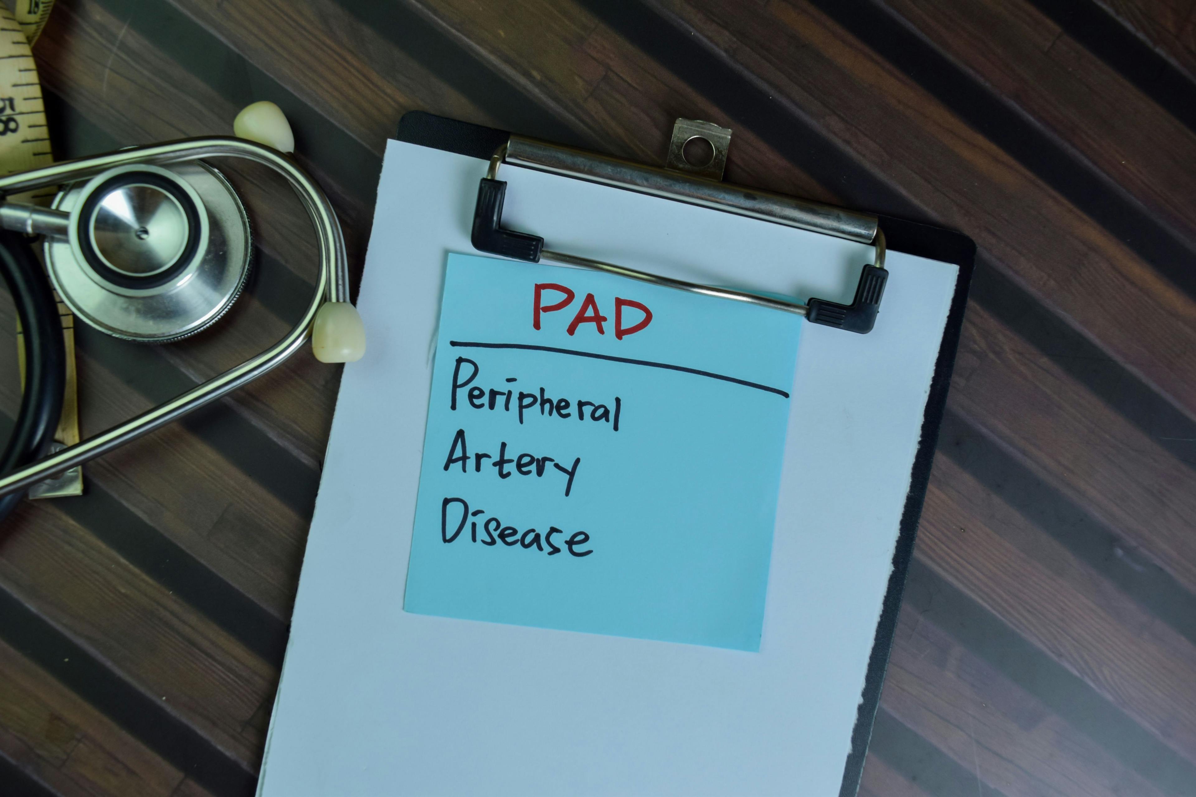 PAD - Peripheral Artery Disease written on sticky note isolated on wooden table.